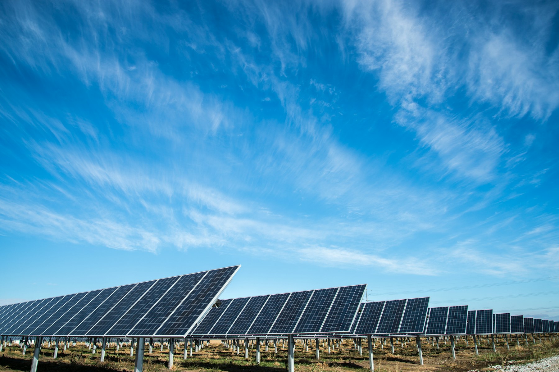 Solar panels collecting afternoon light across a green community landscape